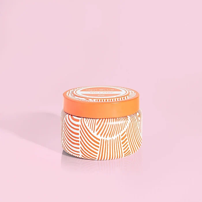 an orange striped candle against a pink background