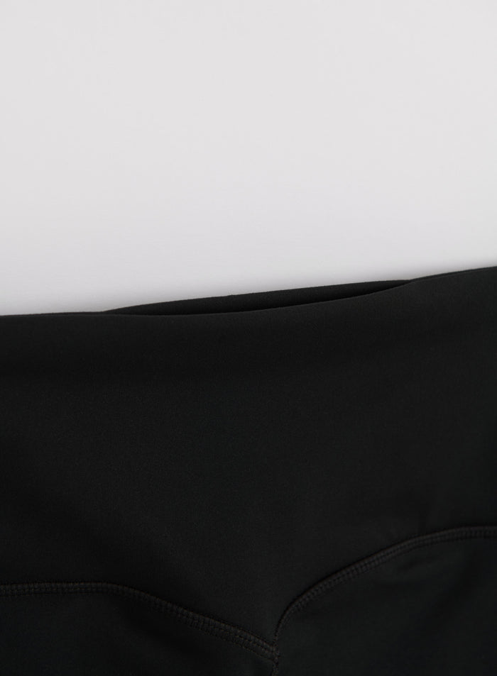 Close-up of the high waistband on black aim'n Sense Contrast Tights with a smooth second skin feel.