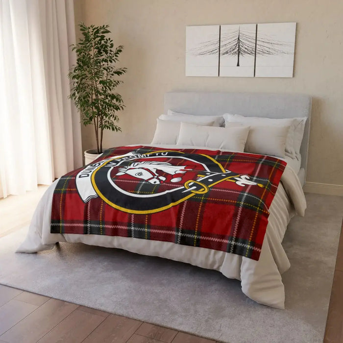Dunbar clan crest throw blanket draped over sofa — full-colour tartan print, white reverse