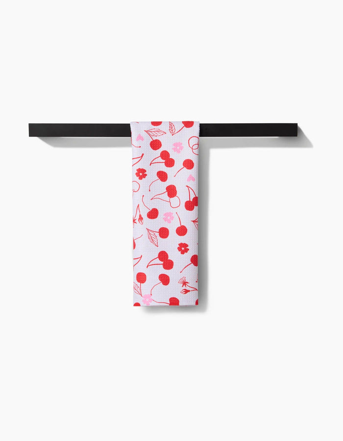 towel with cherry pattern hanging on black towel rack