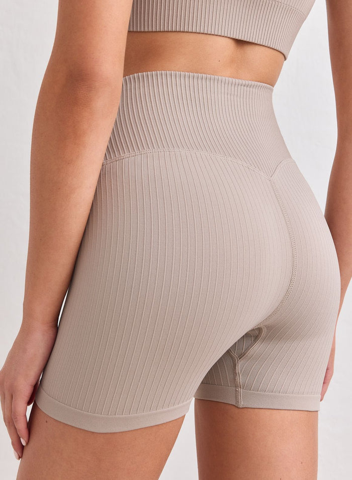 Rear view of dark clay aim'n Ribbed Seamless Midi Biker Shorts with a high waist and ribbed texture. [S-178cm]