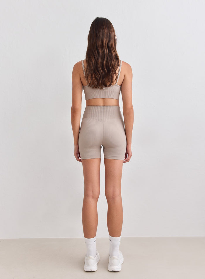 Dark Clay Ribbed Seamless Midi Biker Shorts by aim'n shown from the back with a supportive high waist. [S-178cm]