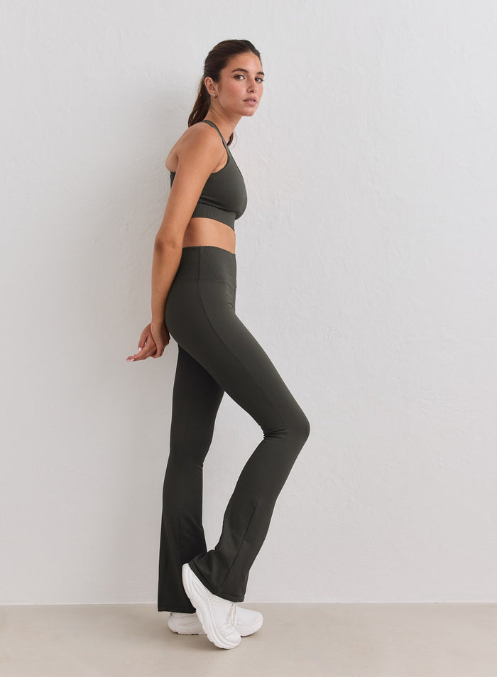Model in dark ivy Ribbed Seamless Flare Tights and matching sports bra by aim'n. [S-178cm]