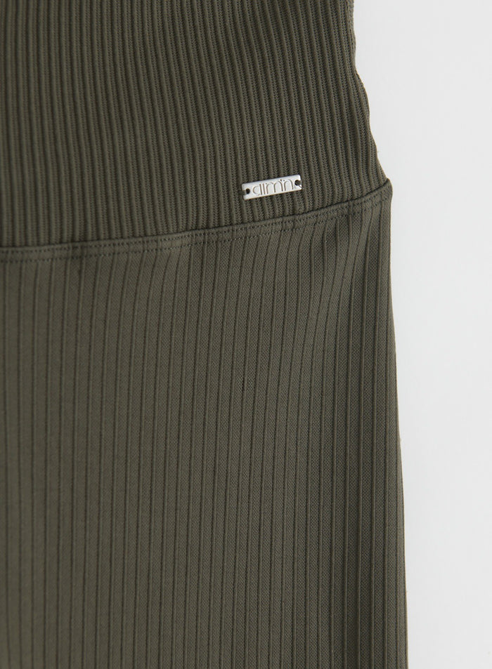 Close-up of dark ivy ribbed seamless flare tights showing the high waistband, ribbed texture and aim'n logo