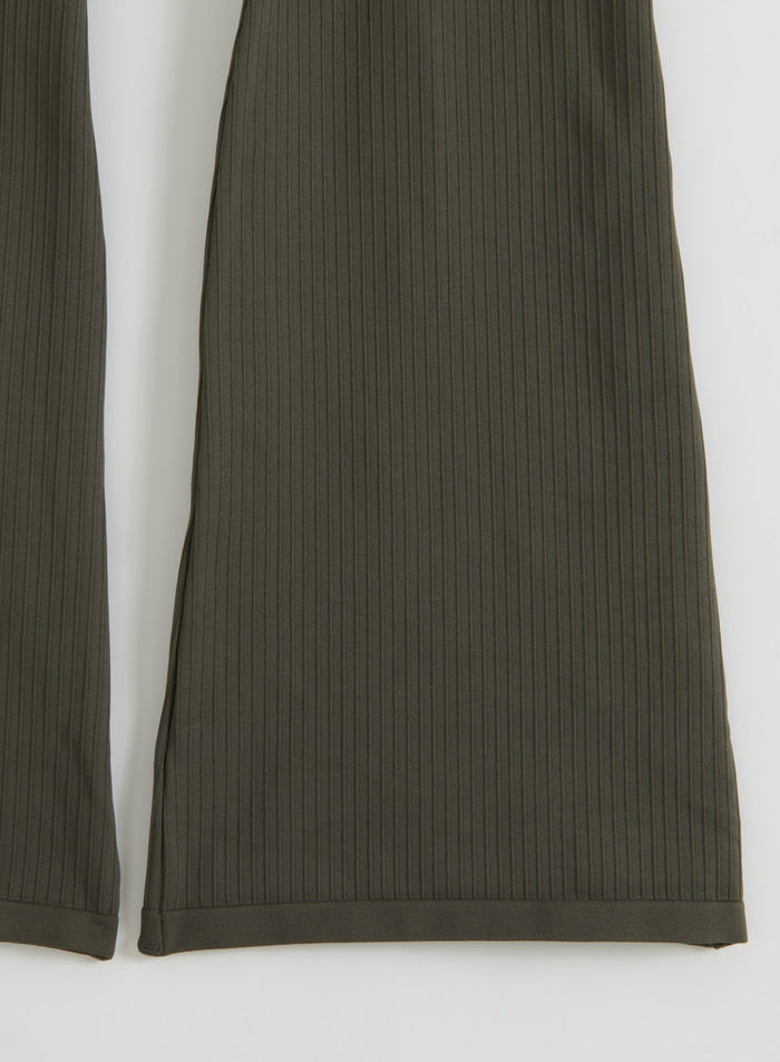 Close-up of dark ivy ribbed seamless flare tights laid flat