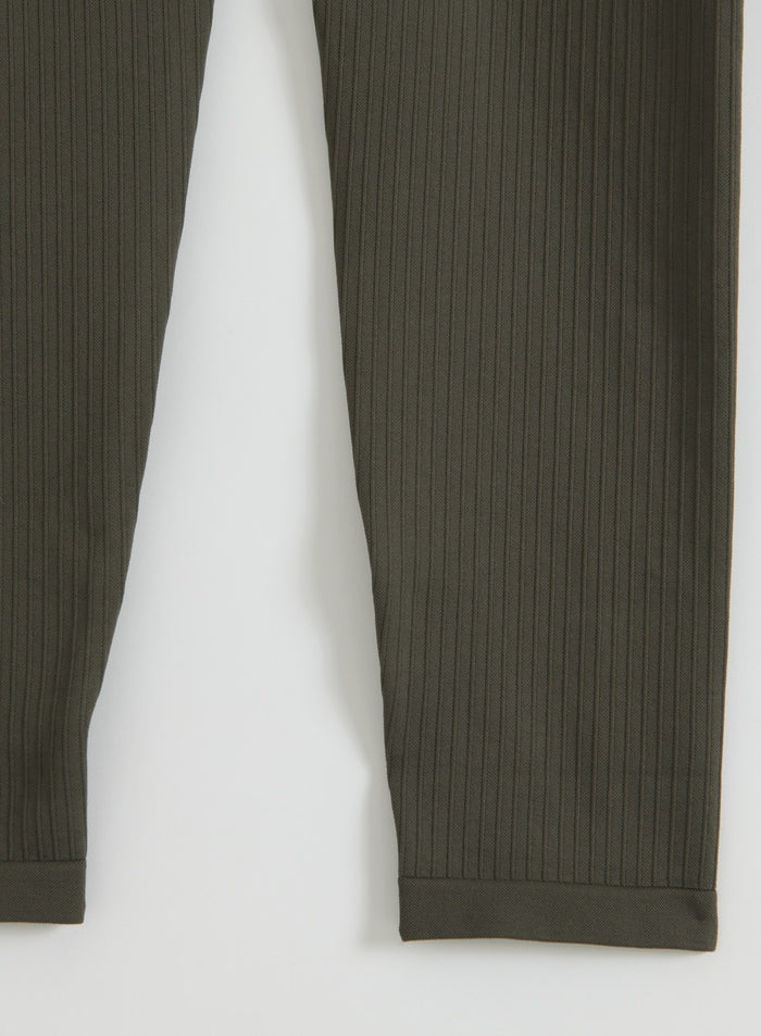 Flat lay of dark ivy ribbed seamless tights showing the vertical ribbed texture and finished hems