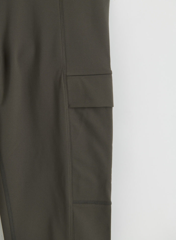 Close-up of dark ivy warming tights showing a side pocket and stitched details