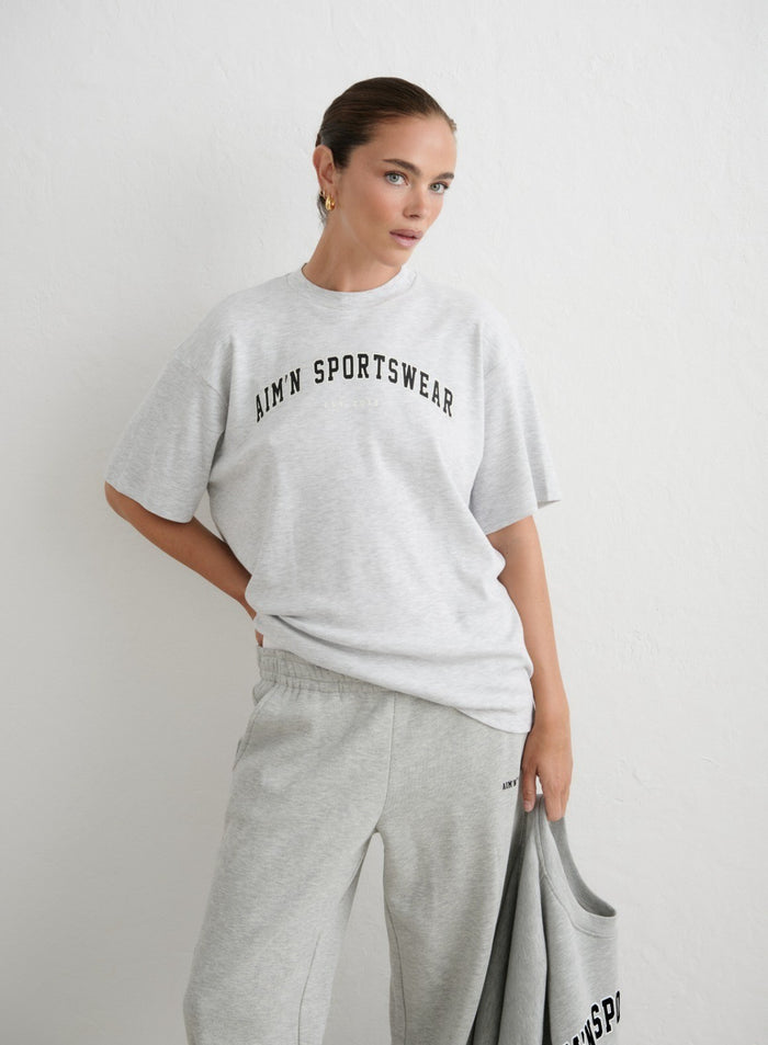 Light grey melange oversized varsity boyfriend t-shirt featuring a black aim'n logo [xs-165cm]