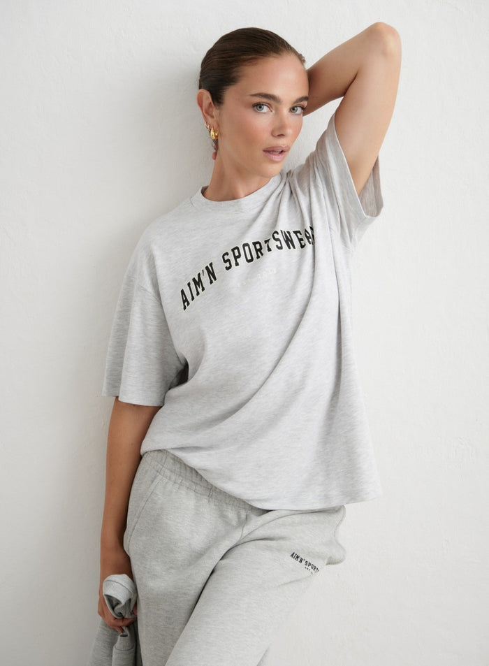 Light grey melange oversized varsity boyfriend t-shirt featuring a sporty aim'n logo print. [xs-165cm]