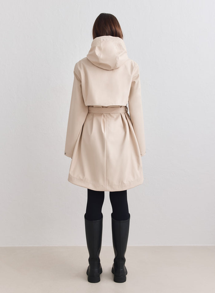 Back view of the aim'n Sand Rain Jacket in beige with a hooded design and belted waist. [M-178cm]