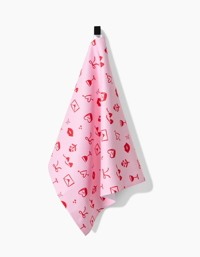 red and pink patterned towel hanging against a white background