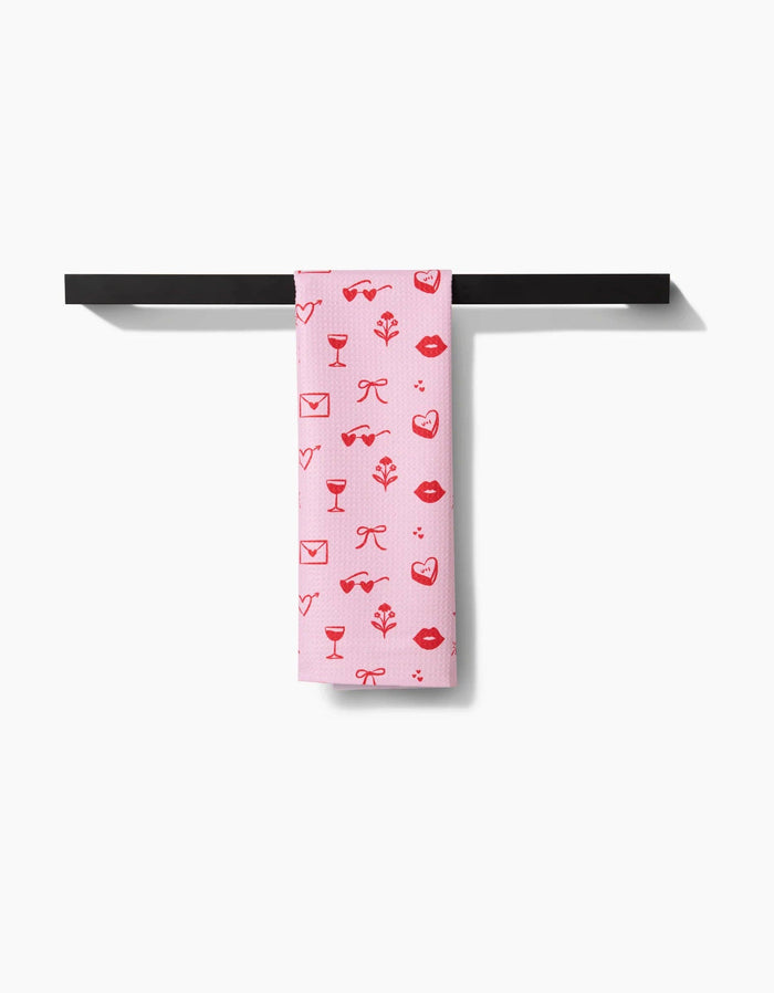 red and pink patterned towel hanging on a black towel rack