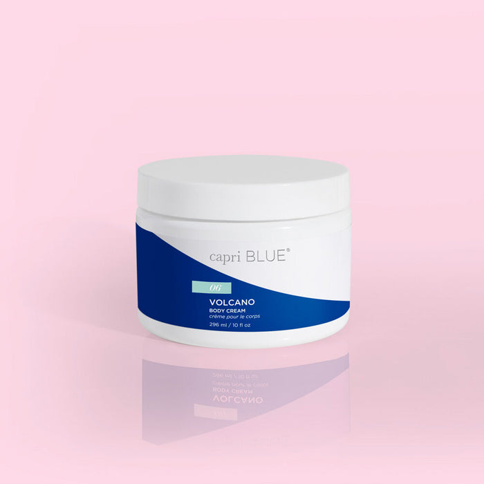 a tub of capri blue volcano body cream against a pink background
